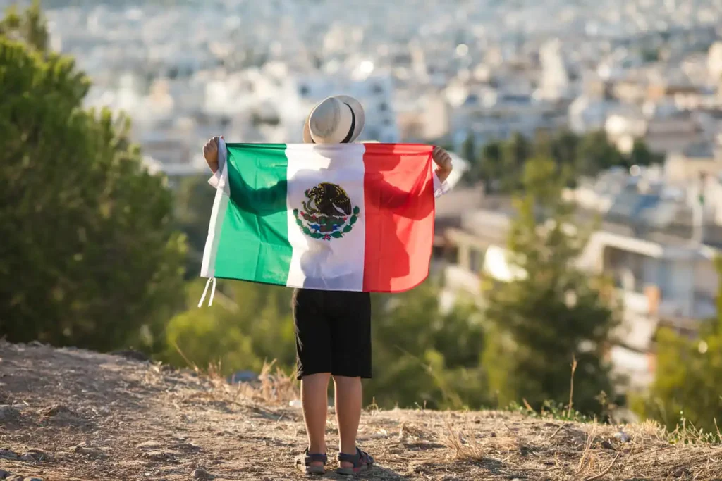 ¿Qué hora es en México ahora? Un niño de pie con una bandera después de que México gana el partido de fútbol